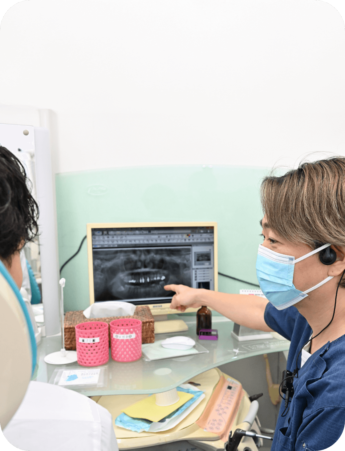 歯科医がレントゲン画像を患者に説明している様子